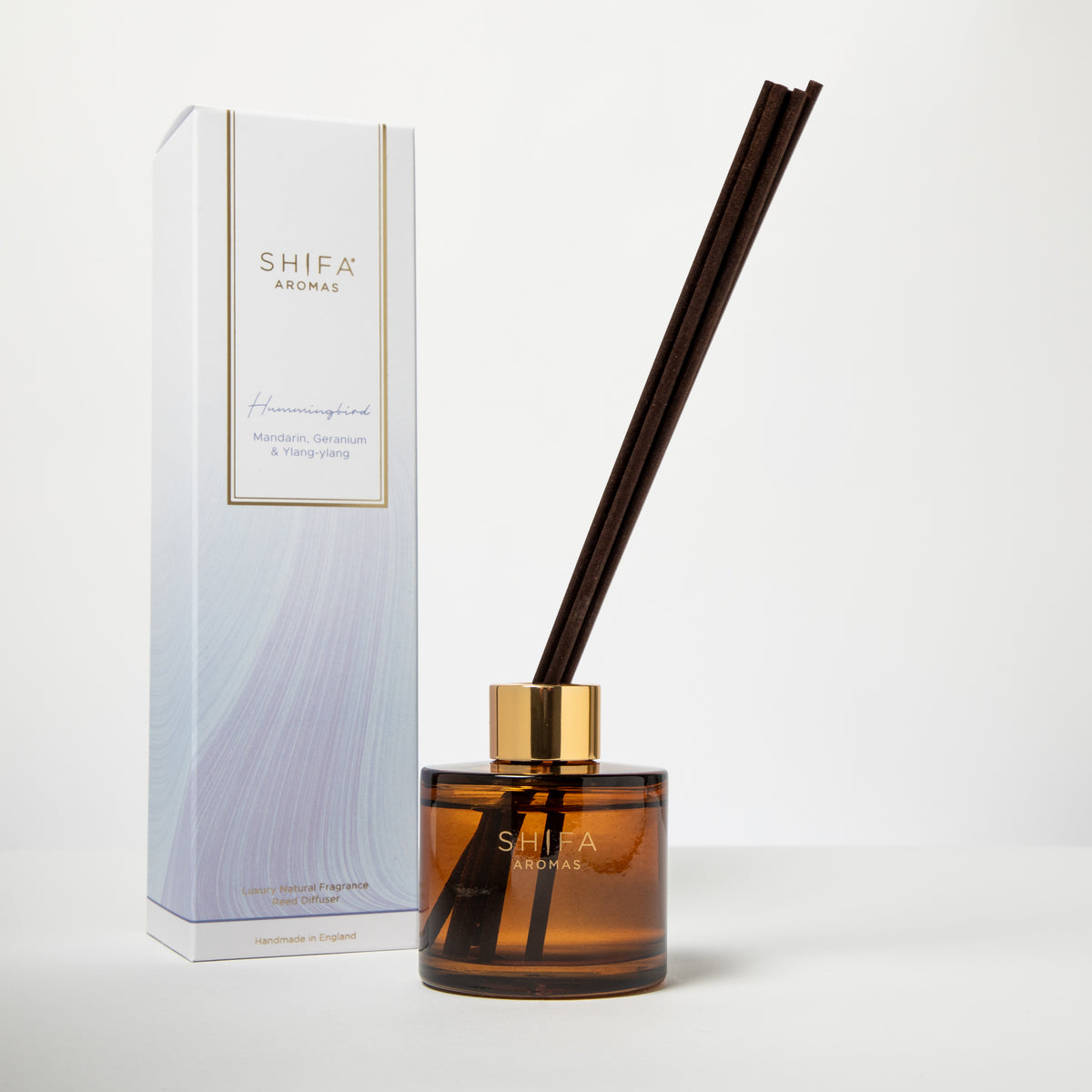 Hummingbird reed diffuser by Ma'wa & Co – amber glass bottle with reed sticks beside gift box